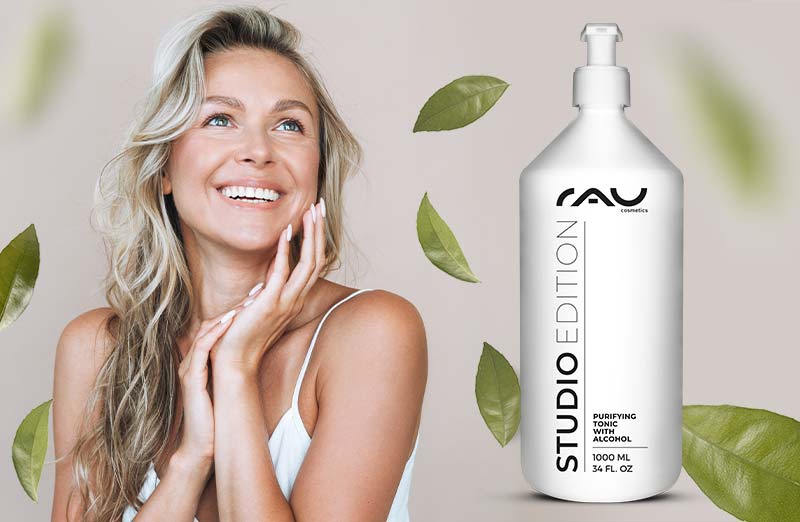 Lächelnde Frau mit dem RAU Purifying Tonic, umgeben von Blättern, in modernen Verpackungen für Problemp Haut.