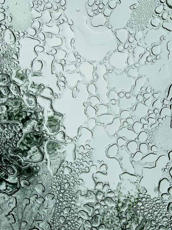 Wassertropfen auf einer glatten Oberfläche, symbolisierend die feuchtigkeitsspendenden Eigenschaften von Hyaluronsäure in der Hautpflege.