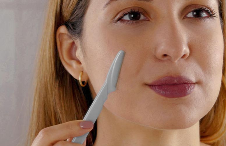 rau-cosmetics_faceblading-02 Frau mit Gesichtsrasierer, der Dermaplaning-Technik anwendet, um abgestorbene Hautzellen und feine Härchen zu entfernen.