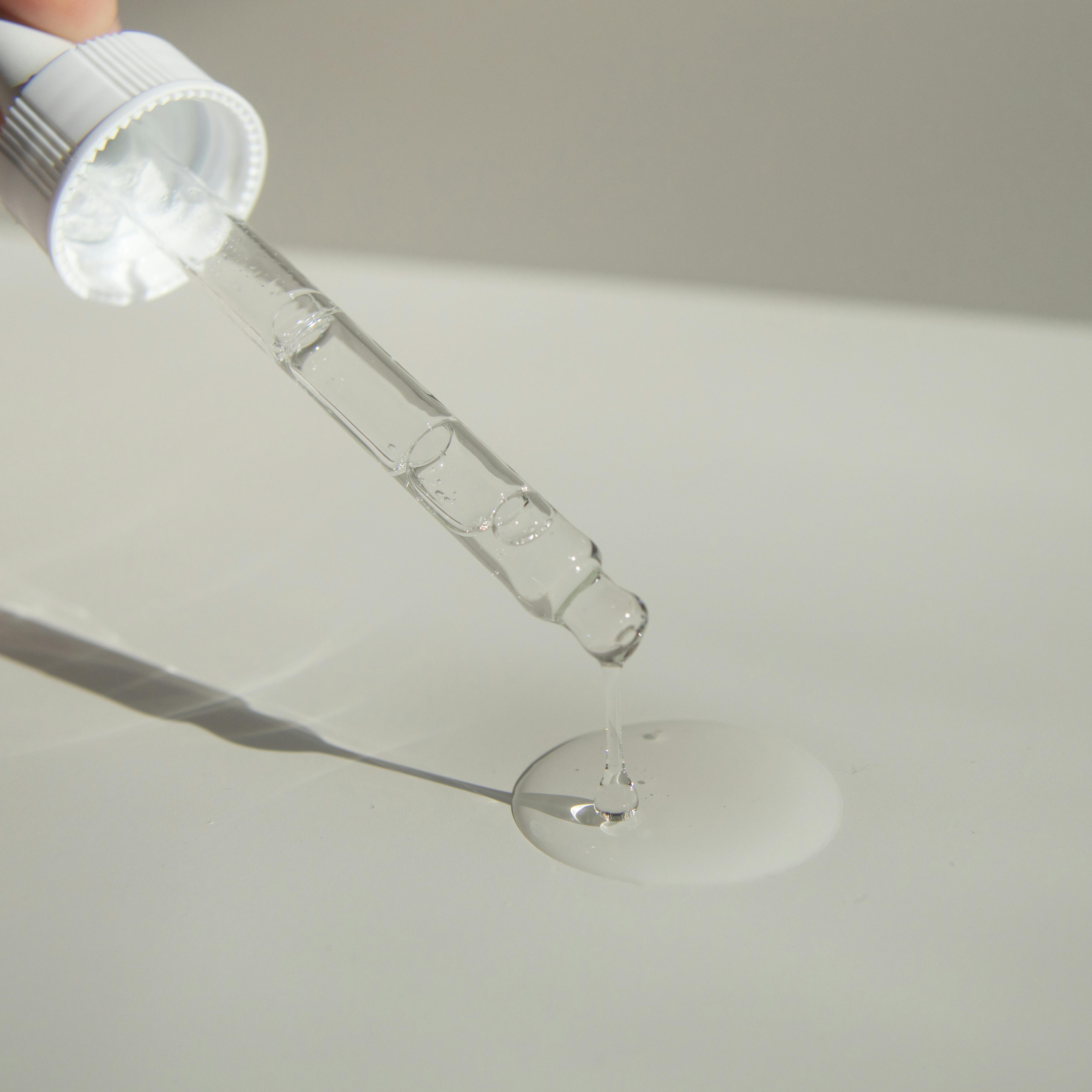 pexels-jill-burrow-6387845 Eine Pipette gibt klares Serum auf eine Oberfläche ab und hebt die Anwendung von Hautpflegeprodukten im Zusammenhang mit Peptiden und Anti-Aging-Vorteilen hervor.