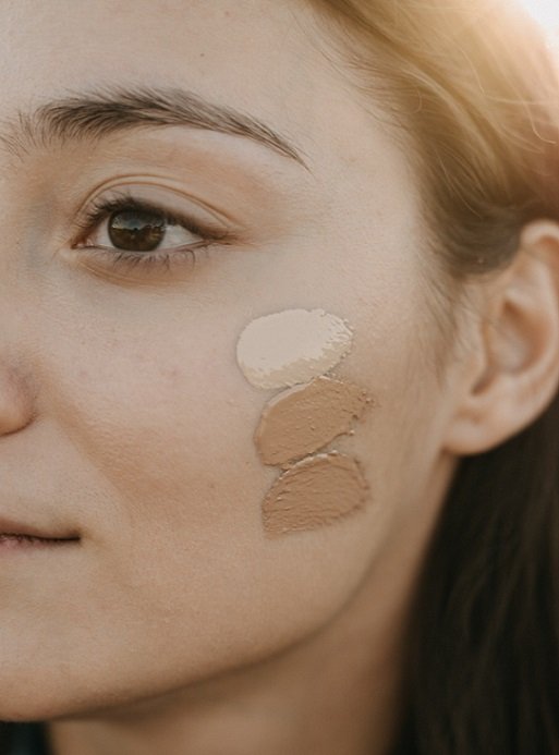 Frau mit verschiedenen BB Cream-Farbtönen auf der Wange, zeigt die Farbintensität und Deckkraft der RAU BB Creams für Hautpflege und Make-up.