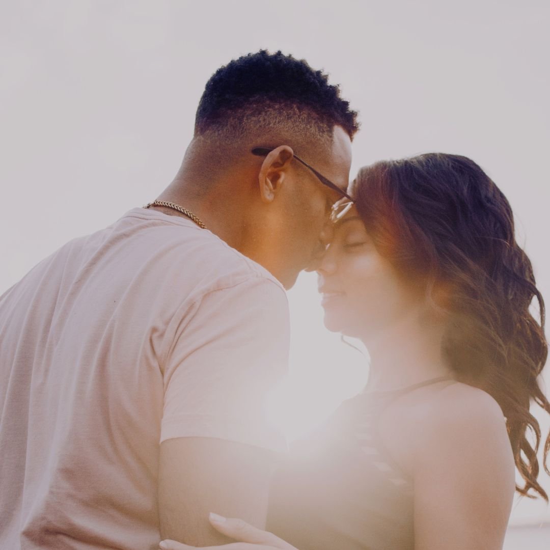 Paar, das sich umarmt und aneinander gelehnt ist, umgeben von warmem Licht, symbolisiert den Einfluss von Liebe und Liebeshormonen auf die Haut.